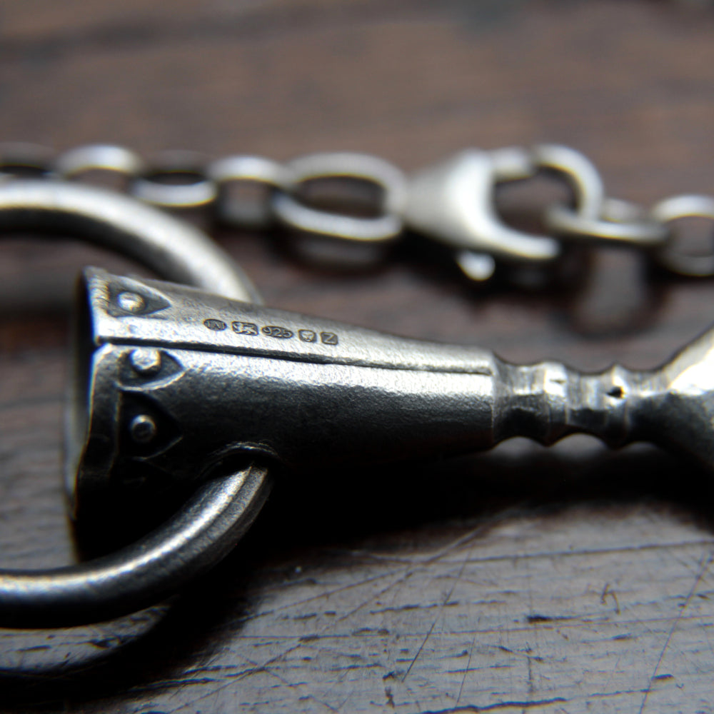 Close-up of official UK hallmarks for Taitaya Forge, stamped on a silver spear pendant