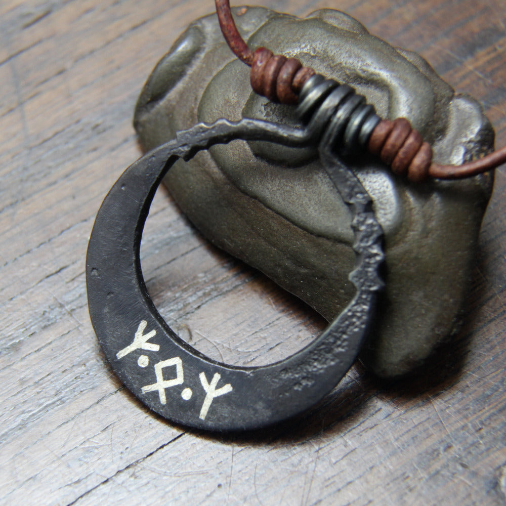 Silver wire inlay of runes on the back of the moon pendant, made and designed by Taitaya Forge